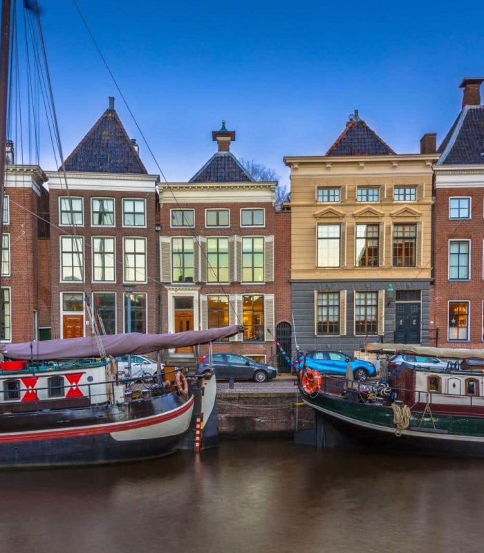 Deux bateaux traditionnels sont amarrés le long du canal sous un ciel clair.