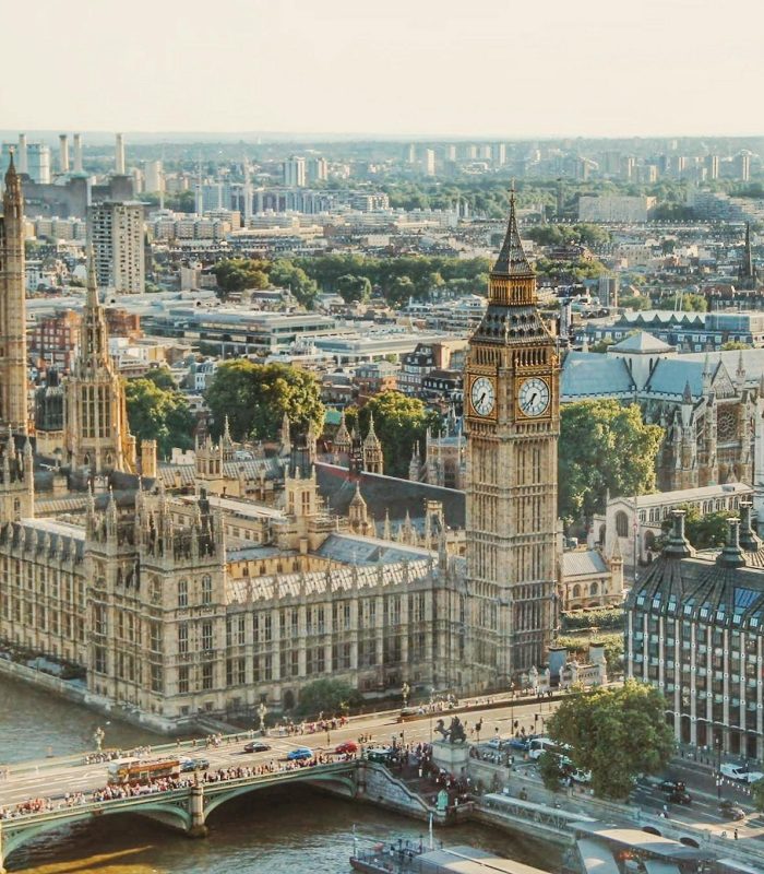 Aerial view of the Palace of Westminster and Big Ben on the banks of the Thames in London, with Westminster Bridge and the buildings of the city in the background on a clear day.